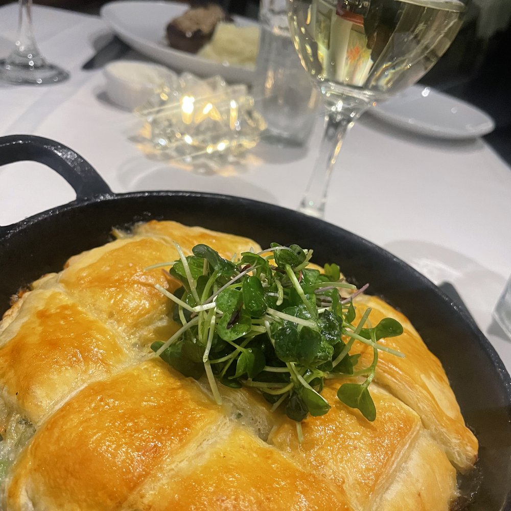 Bloomsbury Bistro - Chicken Pot Pie with micro greens, glass of Riesling - New American Near Me - Raleigh, North Carolina Bloomsbury Bistro - Chicken Pot Pie with micro greens, glass of Riesling - New American Near Me - Raleigh, North Carolina
