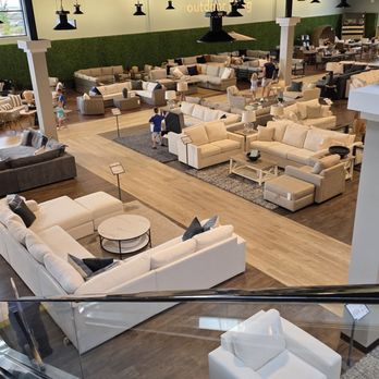 Living Spaces - Huge - A large furniture store showroom with multiple sofas, sectionals, and seating options arranged in different sections, with children and adults browsing. - Home Decor Near Me - Lone Tree, Colorado
