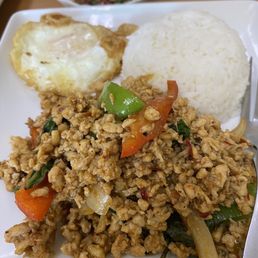 Hot Basil Leaf Chicken - A Thai dish featuring stir-fried ground chicken with basil, served with white rice, a fried egg, and a small bowl of sauce.