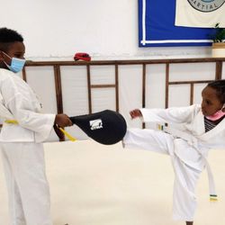 Quantum Martial Arts - Siblings practicing their round kicks after class