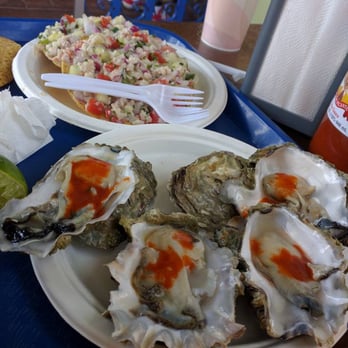 Mariscos La Costa - Raw oysters with hot sauce and ceviche in the background. - Mexican Near Me - Oakland, California Mariscos La Costa - Raw oysters with hot sauce and ceviche in the background. - Mexican Near Me - Oakland, California