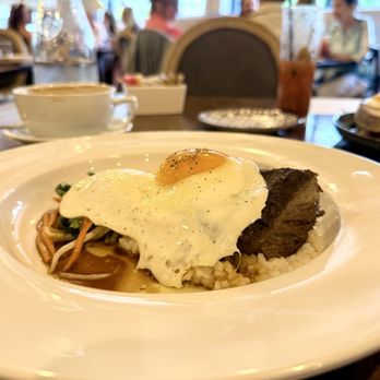 Charmant - The Phomo anise star-braised short rib with a fried egg over rice grits - Tapas/Small Plates Near Me - New Orleans, Louisiana Charmant - The Phomo anise star-braised short rib with a fried egg over rice grits - Tapas/Small Plates Near Me - New Orleans, Louisiana