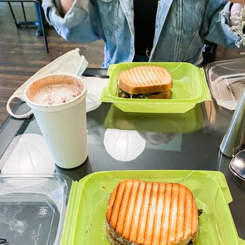 Unbar Cafe - a woman sitting at a table eating a sandwich - Cafes Near Me - Cleveland, Ohio Unbar Cafe - a woman sitting at a table eating a sandwich - Cafes Near Me - Cleveland, Ohio