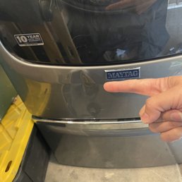 Damage to washer door from Grace Moving Co. not protecting it while moving.