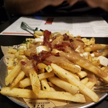 Stack 571 Burger & Whiskey Bar - Poutine: fries covered in bacon, gravy and fresh mozzarella cheese garnished with fresh Rosemary and parsley delicious. - American Near Me - Lake Tapps, Washington Stack 571 Burger & Whiskey Bar - Poutine: fries covered in bacon, gravy and fresh mozzarella cheese garnished with fresh Rosemary and parsley delicious. - American Near Me - Lake Tapps, Washington