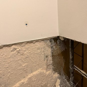 Santiago Vera - a corner of a bathroom with a hole in the wall - Flooring Near Me Santiago Vera - a corner of a bathroom with a hole in the wall - Flooring Near Me