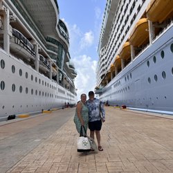 Agave Travel - Bill and I standing between 2 beauties. Royal Caribbean and Carnival cruise ships in port Cozumel.