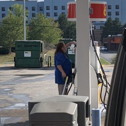 Shell - Employee smoking a cigarette while cleaning gas pumps