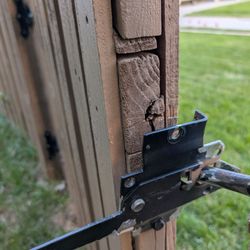 Big John's Basics - A very broken latch, especially the top screw that has fallen out of the cracked wood horizontal beam.