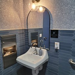 Beautiful blue tiled and wallpapered restroom