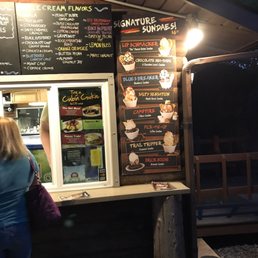 a woman standing in front of a food stand