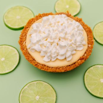 Coastal Key Lime Pie - a key lime pie surrounded by lime slices - Desserts Near Me - Millsboro, Delaware Coastal Key Lime Pie - a key lime pie surrounded by lime slices - Desserts Near Me - Millsboro, Delaware
