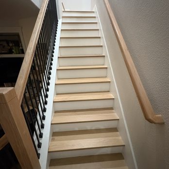 Four Square Restoration - Stairway (looking up) with new flooring, new wrought iron spindles and wood hand rails. - Damage Restoration Near Me Four Square Restoration - Stairway (looking up) with new flooring, new wrought iron spindles and wood hand rails. - Damage Restoration Near Me