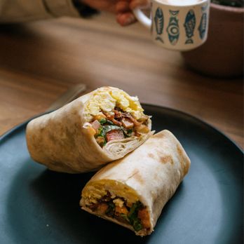 Moss and Milk - Brekky Burrito: xl tortilla - olive oil eggs - mayo - cheddar - kale - jalapeño pico de gallo - hash browns - avocado or bacon - baked beans - Coffee & Tea Near Me - Tofino, British Columbia Moss and Milk - Brekky Burrito: xl tortilla - olive oil eggs - mayo - cheddar - kale - jalapeño pico de gallo - hash browns - avocado or bacon - baked beans - Coffee & Tea Near Me - Tofino, British Columbia