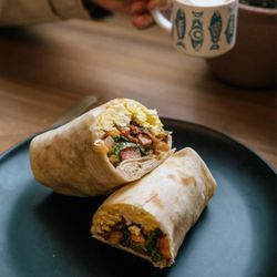 Moss and Milk - Brekky Burrito: xl tortilla - olive oil eggs - mayo - cheddar - kale - jalapeño pico de gallo - hash browns - avocado or bacon - baked beans