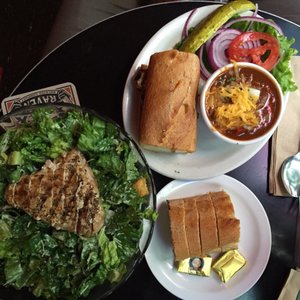 Photo of Two Bells Bar & Grill - Seattle, WA, United States. ahi Caesar salad with complimentary bread (14.95) and chicken sandwich with chili ($11.95)