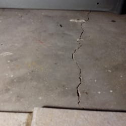 Cracked foundation under stove - loose kitchen tiles nearby.
