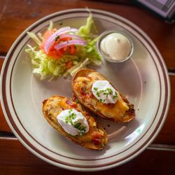 Kelly’s Irish Pub - MELTED DUBLINER CHEDDAR, CRISPY BACON, chives, sour cream BEDDED IN A CRISPT POTATO SKIN