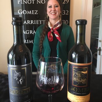 Stoltz Vineyards - a woman standing in front of three bottles of wine - Wineries Near Me - Hood River, Oregon Stoltz Vineyards - a woman standing in front of three bottles of wine - Wineries Near Me - Hood River, Oregon