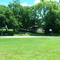 Eva Walker Memorial Park - Basketball court with a stack of stadium seating and a trash can