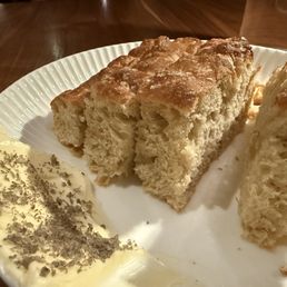 Focaccia was served warm with a light oil drizzle and salted butter on the side Focaccia was served warm with a light oil drizzle and salted butter on the side