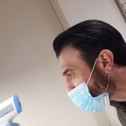 Ditmars Family Dental - Taking temperature during covid visits prior to stepping in.