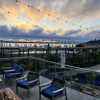 The Pineapple Club - a deck with chairs and a fire pit - Bars Near Me - Newport, Rhode Island