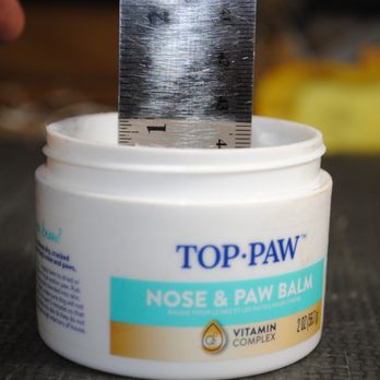 PetSmart - A container of Top Paw Nose & Paw Balm with a metal ruler inserted into it, placed on a dark surface. - Pet Stores Near Me - Bolingbrook, Illinois