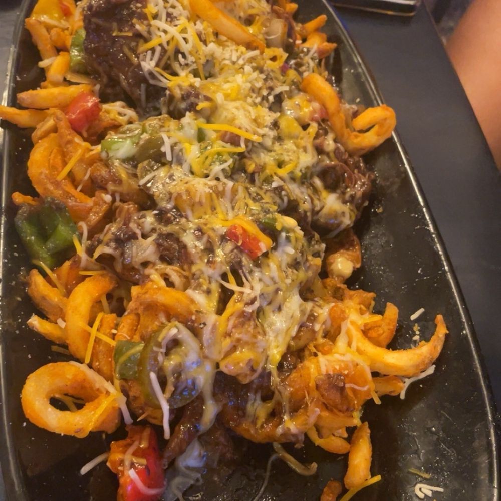 Godfreys - Reggae fries... curly seasoned fries topped with oxtail gravy, cheese and jalapeños.... - Caribbean Near Me - Flowood, Mississippi