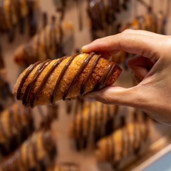 CAO Bakery & Cafe - A hand holding a nutella pastry. - Cuban Near Me - Hollywood, Florida