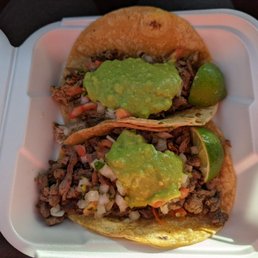 Two tacos: carnitas (top) and carne asada (bottom), both served with a dollop of guacamole and light pico de gallo. Two tacos: carnitas (top) and carne asada (bottom), both served with a dollop of guacamole and light pico de gallo.