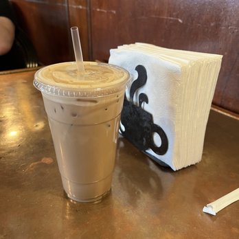 Coffee Depot - Medium iced chai latte next to napkin holder for size comparison. - Coffee & Tea Near Me - Warren, Rhode Island