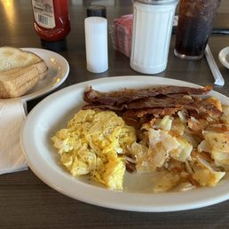 Two eggs scrambled, bacon, American fries and white toast Two eggs scrambled, bacon, American fries and white toast