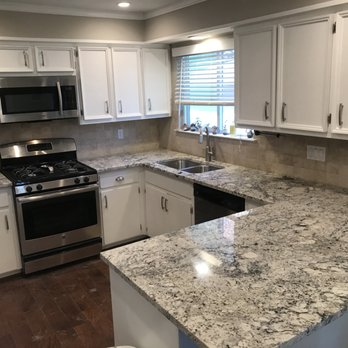 A+ Countertops - A huge and beautiful island made from a white slab off granite with unique veins flow. - Countertop Installation Near Me