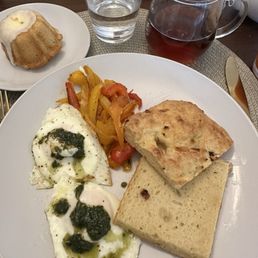 Gluten free focaccia bread, fried eggs with pesto and bell peppers, gluten free orange pastry. Gluten free focaccia bread, fried eggs with pesto and bell peppers, gluten free orange pastry.