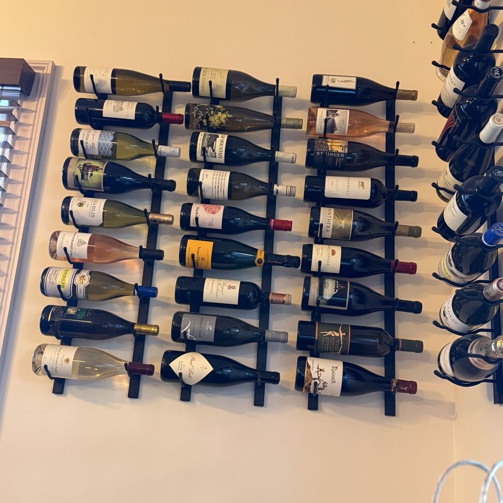 Wine racks hang around the room displaying some yummy wines. Wine racks hang around the room displaying some yummy wines.