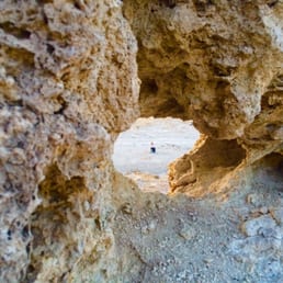 Trona Pinnacles and a girl through the hole waiting for sunset Trona Pinnacles and a girl through the hole waiting for sunset