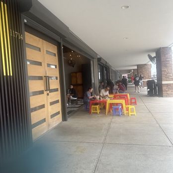 HEM Kitchen And Bar - Outside of restaurant shows how restaurants are like in Vietnam, sitting outside using plastic chairs and tables. - Vietnamese Near Me - Houston, Texas