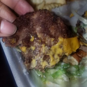 American Deli - a hand holding a hamburger and french fries - Chicken Wings Near Me - Memphis, Tennessee