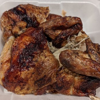 Chicka Loca - Whole chicken - The image shows a whole grilled chicken with browned, slightly charred skin, placed in a foam takeout container. The chicken appears cooked thoroughly with visible grill marks and crispy skin, and is served without additional sides or garnishes. The container suggests it is a takeout meal, possibly from a restaurant specializing in Peruvian-style charcoal chicken. - Peruvian Near Me - Fairfax, Virginia