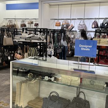 Macy's - A retail store section showcasing designer handbags, accessories, and hats, with a sign labeled 'Designer Steals' and various bags on shelves and racks. - Department Stores Near Me - Albuquerque, New Mexico