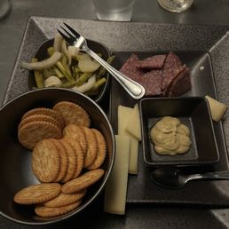 This is what they call a charcuterie board.  What a joke. Ritz crackers and a few pieces or cheese and mustard. Pickled vegetables $ 28.00.