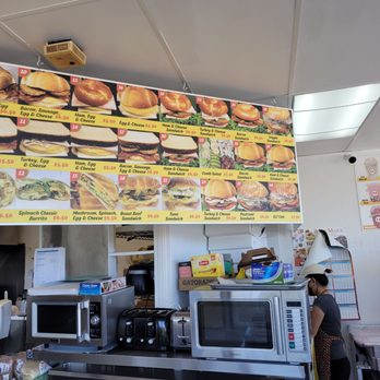 Donut Basket - a woman standing in front of a menu board - Donuts Near Me - Milpitas, California