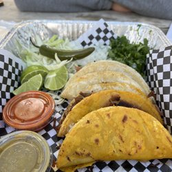 Fusion Tacos - Crunchy and soft goat tacos with sauce, cilantro, and onions