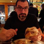 Photo of L’Express - New York, NY, United States. Hubby loving his burger (gruyere cheese)