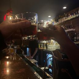 a person pouring a drink at the bar