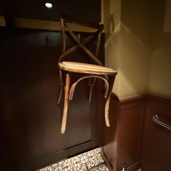 Inside Passage - Random chair hanging on the wall in the bathroom haha - Cocktail Bars Near Me - Seattle, Washington