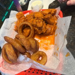 a basket of fried chicken and onion rings a basket of fried chicken and onion rings