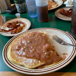 Homemade pancakes with homemade rhubarb sauce with yummy bacon coffee and ice tea . Homemade pancakes with homemade rhubarb sauce with yummy bacon coffee and ice tea .