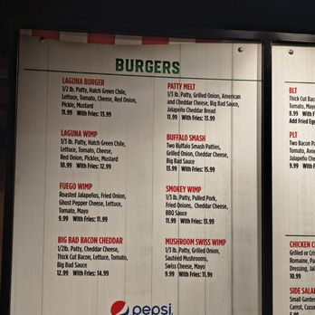 Laguna Burger - November 2025 - A menu board features a list of burger options including Laguna Burger, Patty Melt, Buffalo Smash, and others, with prices and ingredients. The board is part of Laguna Burger in Albuquerque, NM, and includes details about each burger's ingredients and pricing, with some options served with fries. The menu is printed on a light-colored background with green and red text, and a partial Pepsi logo is visible at the bottom. - Burgers Near Me - Albuquerque, New Mexico